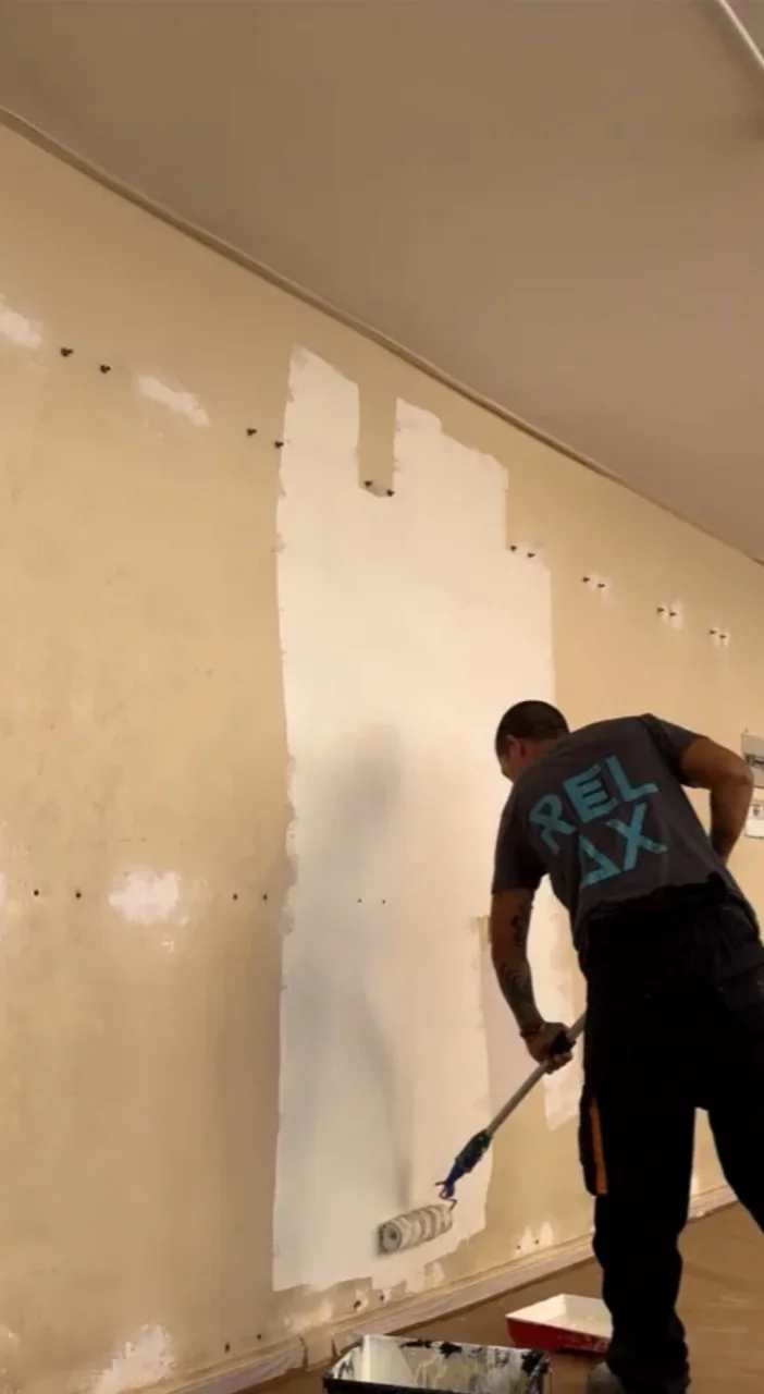 Moisés trabajando en la pintura de una vivienda